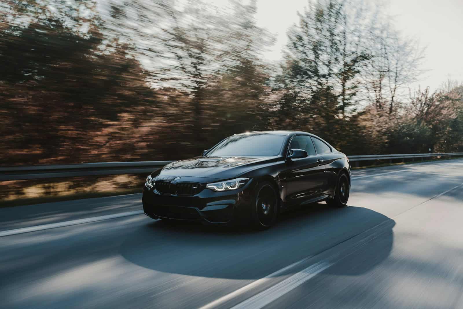 Photo by Rodan Can black BMW coupe parked on road near trees